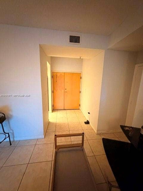 9755 NW 52nd Street, #218, Doral, FL 33178 Entryway featuring double wood-finish doors and neutral tile flooring
