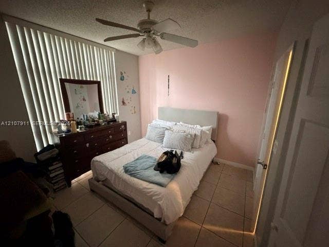 9755 NW 52nd Street, #218, Doral, FL 33178 Bedroom featuring ceramic tile flooring, vertical window blinds, and a ceiling fan with integrated lighting