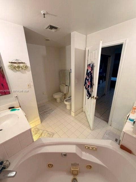 9755 NW 52nd Street, #218, Doral, FL 33178 Bathroom featuring a white corner jetted soaking tub, tiled flooring, built-in vanity, toilet, and bidet