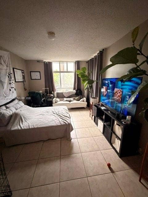 9755 NW 52nd Street, #218, Doral, FL 33178 Neutral-toned interior space featuring ceramic tile flooring, a large window with mounted curtain rods, and a ceiling-mounted light fixture
