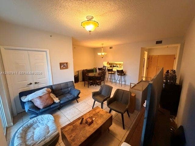 9755 NW 52nd Street, #218, Doral, FL 33178 Open-concept interior featuring neutral tile flooring, dual-light ceiling fixtures, and a kitchen pass-through window with an integrated breakfast bar