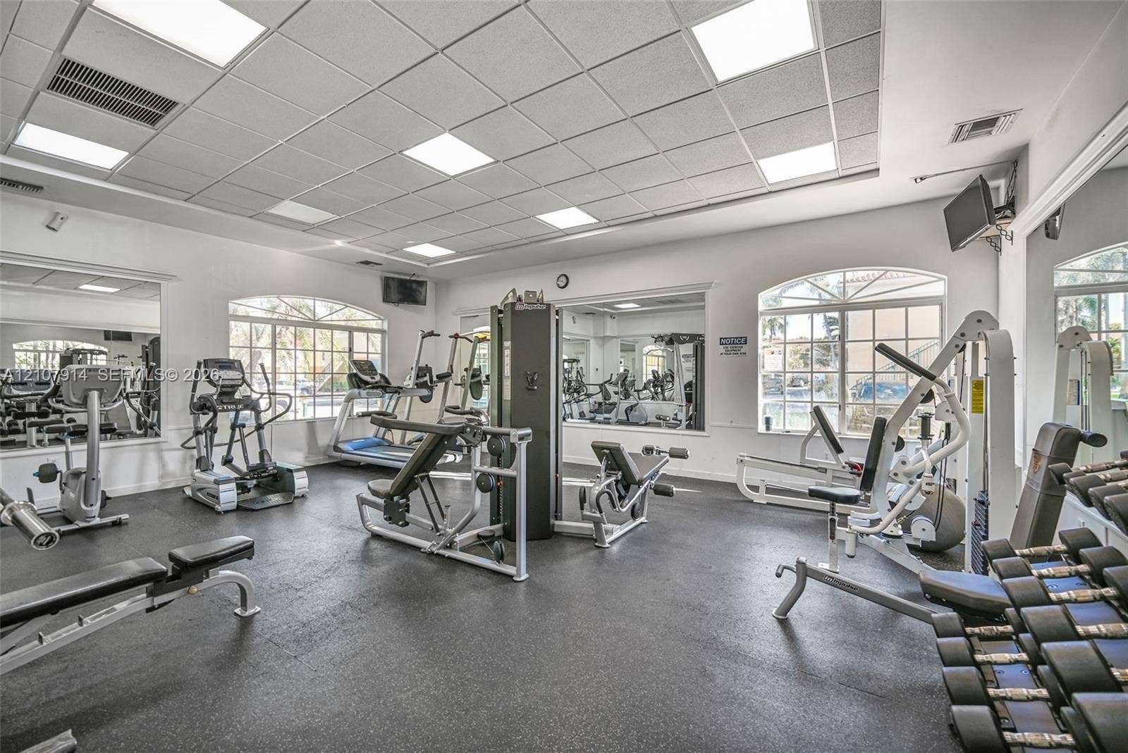 7340 NW 114th Avenue, #205, Doral, FL 33178 Fitness center featuring a drop ceiling with recessed panel lighting, rubberized flooring, and large wall-mounted mirrors