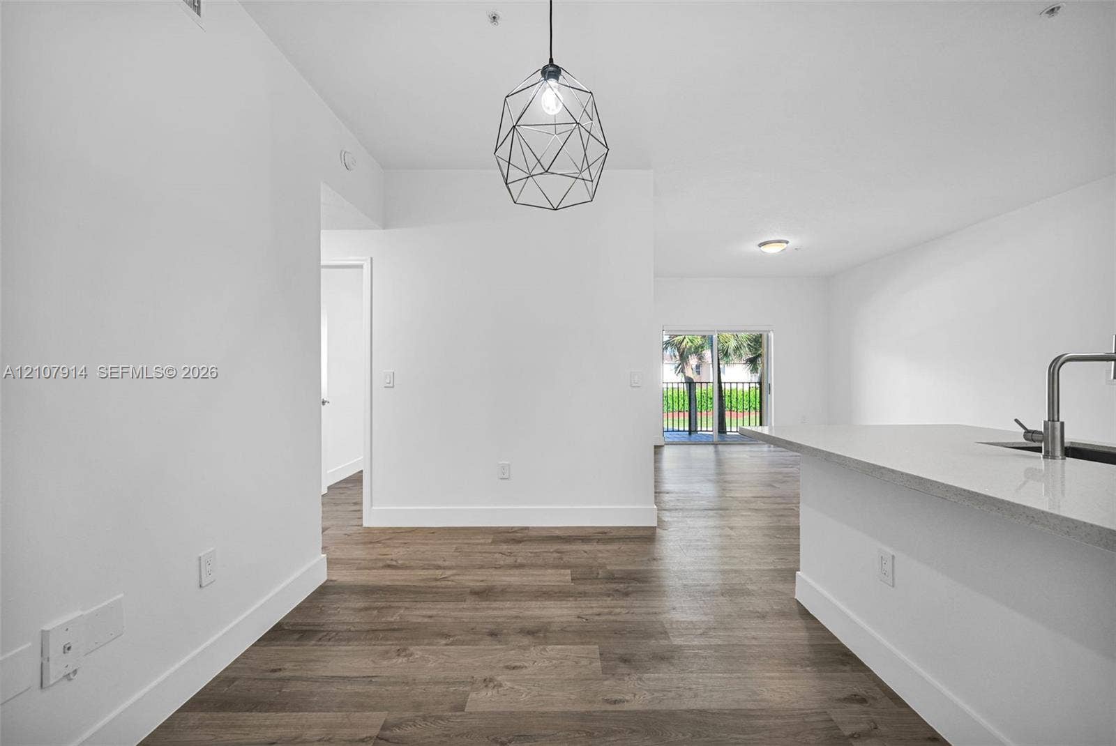 7340 NW 114th Avenue, #205, Doral, FL 33178 Wood-finish flooring throughout, geometric pendant lighting, stone-surface kitchen island, and metal-finish gooseneck faucet