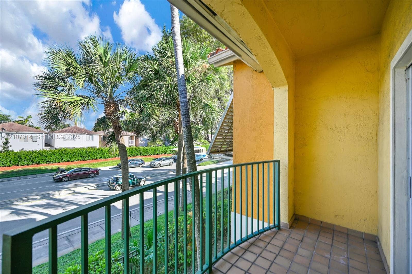 7340 NW 114th Avenue, #205, Doral, FL 33178 Covered balcony featuring tile flooring, an arched ceiling, and a green metal railing