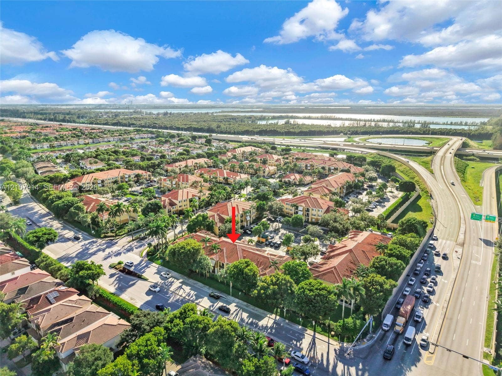 7340 NW 114th Avenue, #205, Doral, FL 33178 Aerial view of multi-story residential complex featuring red tile roofs, mature trees, and landscaped grounds