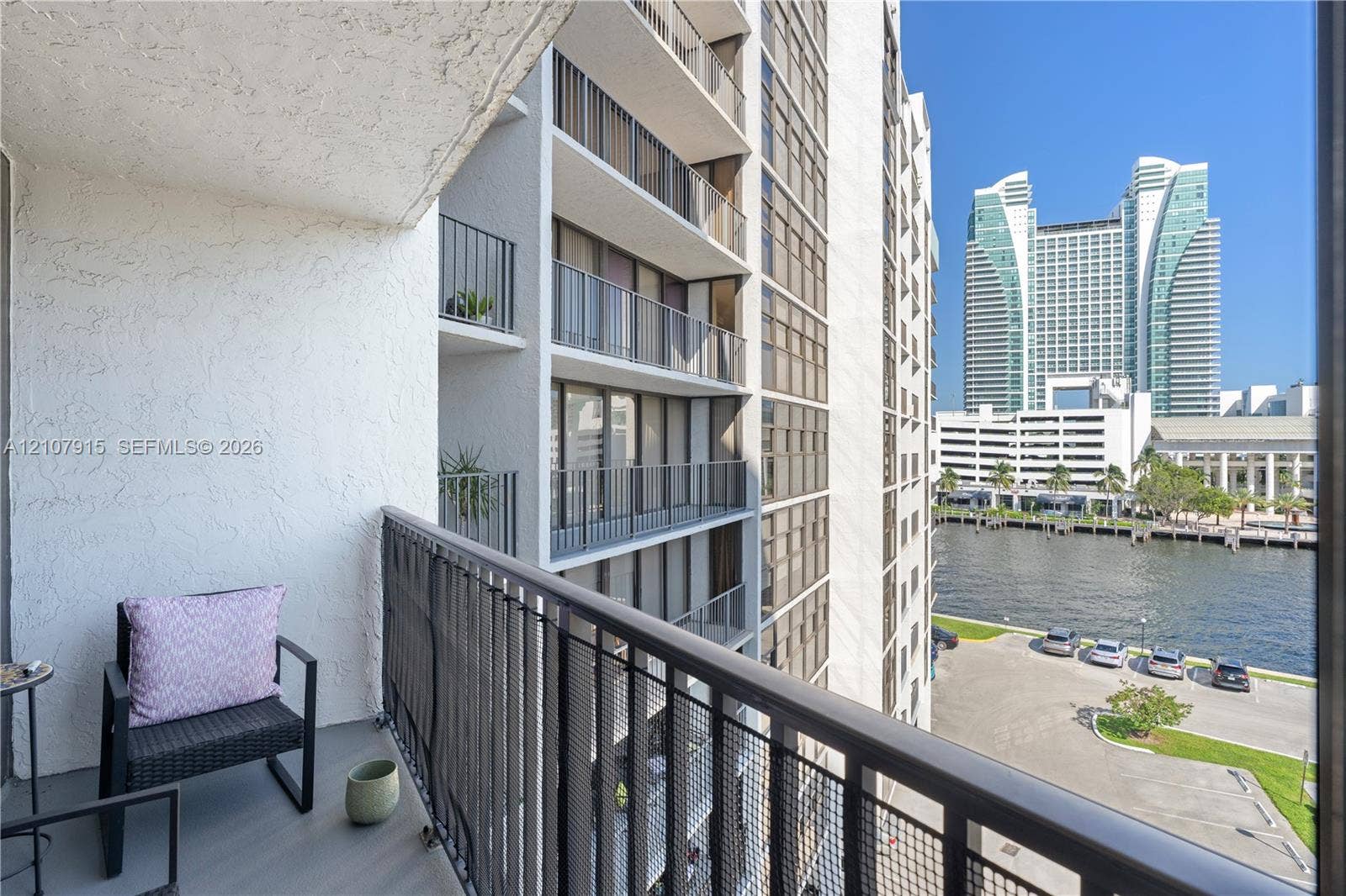 400 Leslie Drive, #622, Hallandale Beach, Hallandale Beach, FL 33009 Private balcony featuring metal mesh railing, textured stucco wall, and exterior lighting, overlooking the water and urban skyline