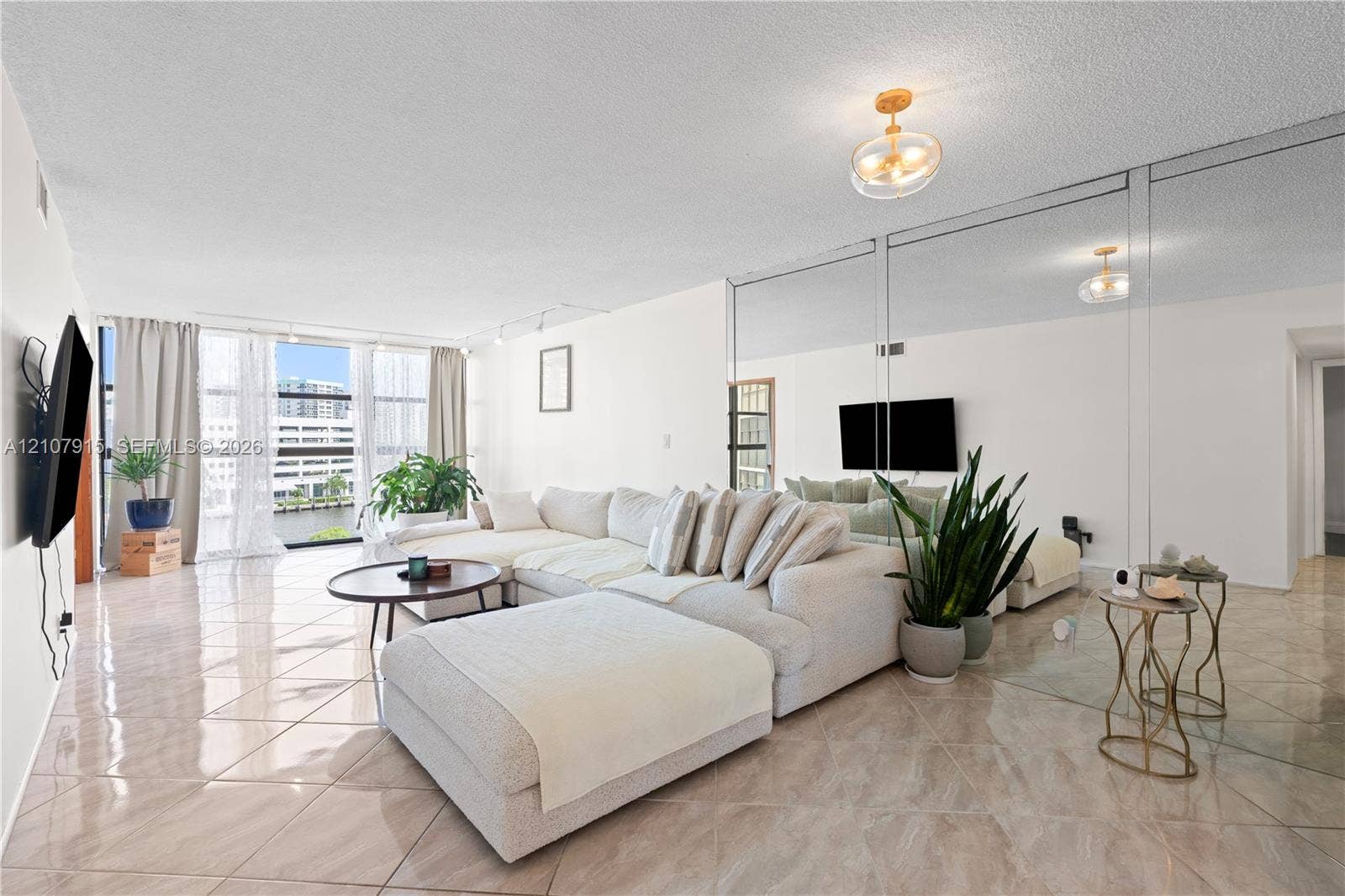 400 Leslie Drive, #622, Hallandale Beach, Hallandale Beach, FL 33009 Living area featuring oversized floor-to-ceiling windows, polished tile flooring, full-wall mirrored paneling, and a contemporary flush-mount ceiling light fixture