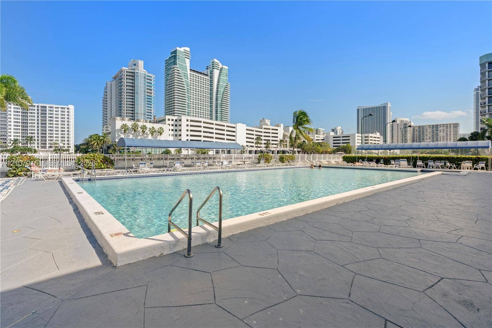 400 Leslie Drive, #622, Hallandale Beach, Hallandale Beach, FL 33009 Swimming pool with stone-patterned decking, metal perimeter fencing, and concrete coping