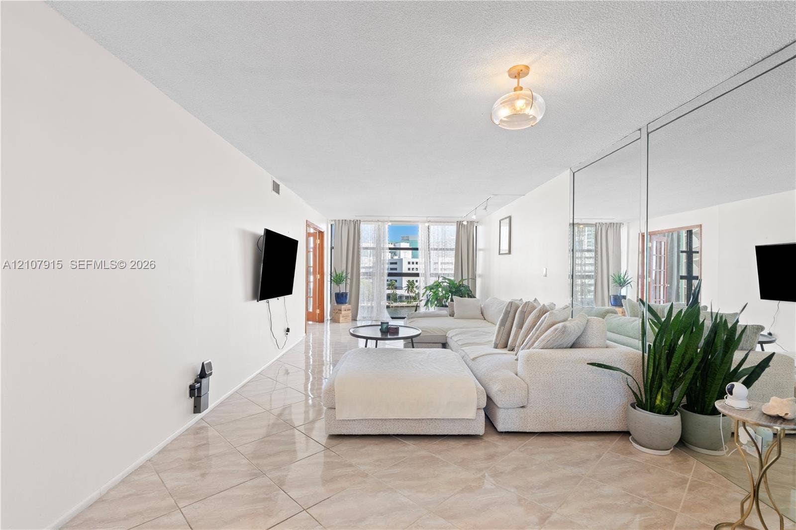 400 Leslie Drive, #622, Hallandale Beach, Hallandale Beach, FL 33009 Floor-to-ceiling mirrored wall, polished tile flooring, glass-paneled entry door, and floor-to-ceiling windows with balcony access