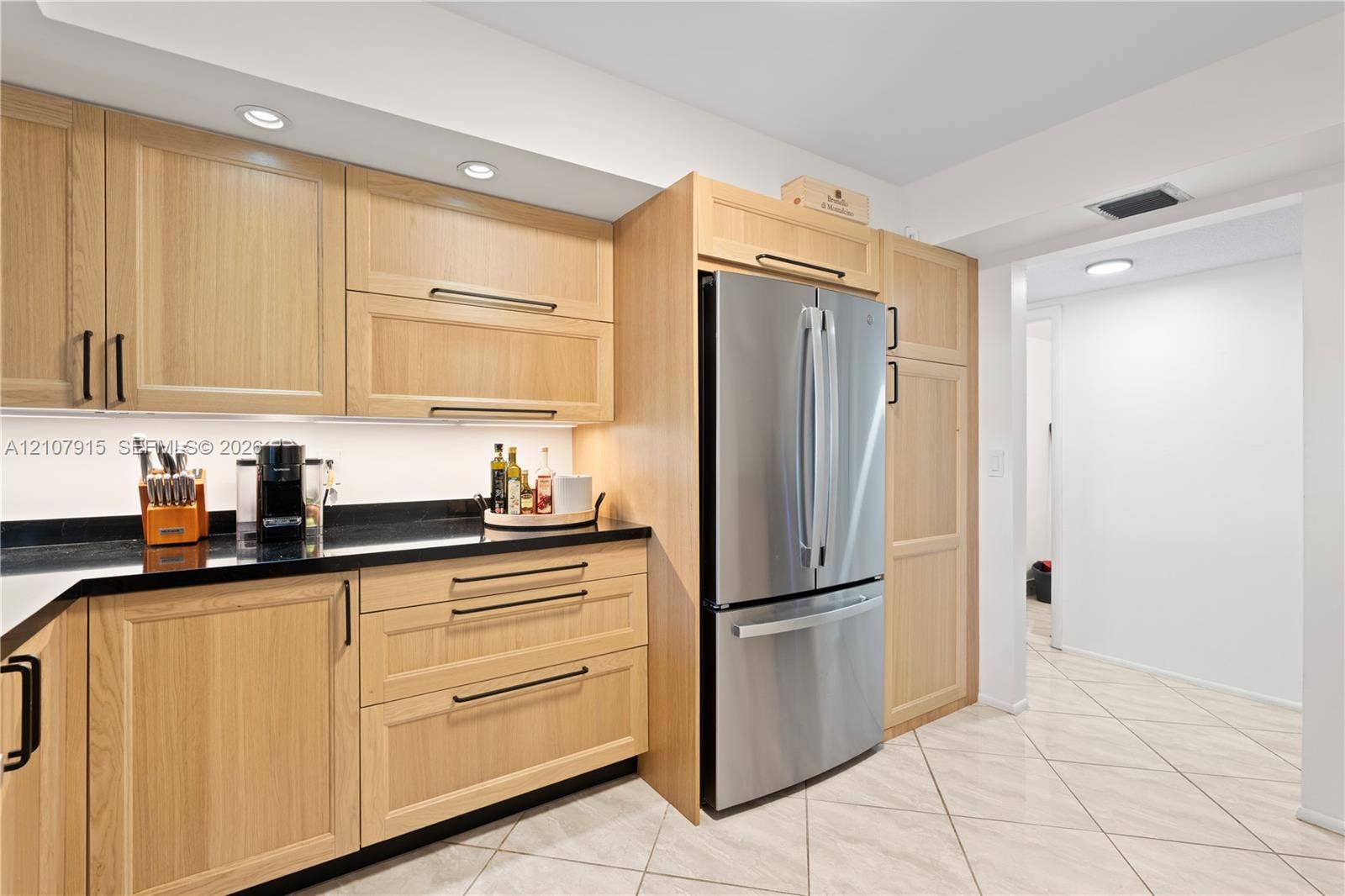 400 Leslie Drive, #622, Hallandale Beach, Hallandale Beach, FL 33009 Light wood-finish cabinetry, dark stone countertops, stainless steel French-door refrigerator, under-cabinet lighting, and neutral ceramic tile flooring
