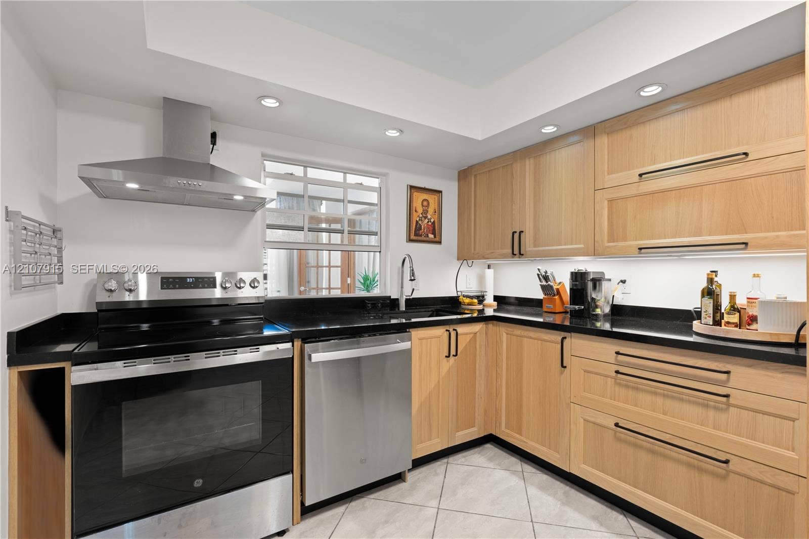 400 Leslie Drive, #622, Hallandale Beach, Hallandale Beach, FL 33009 Kitchen featuring light wood-finish cabinetry, dark solid-surface countertops, stainless steel appliances, a recessed range hood, and tile flooring