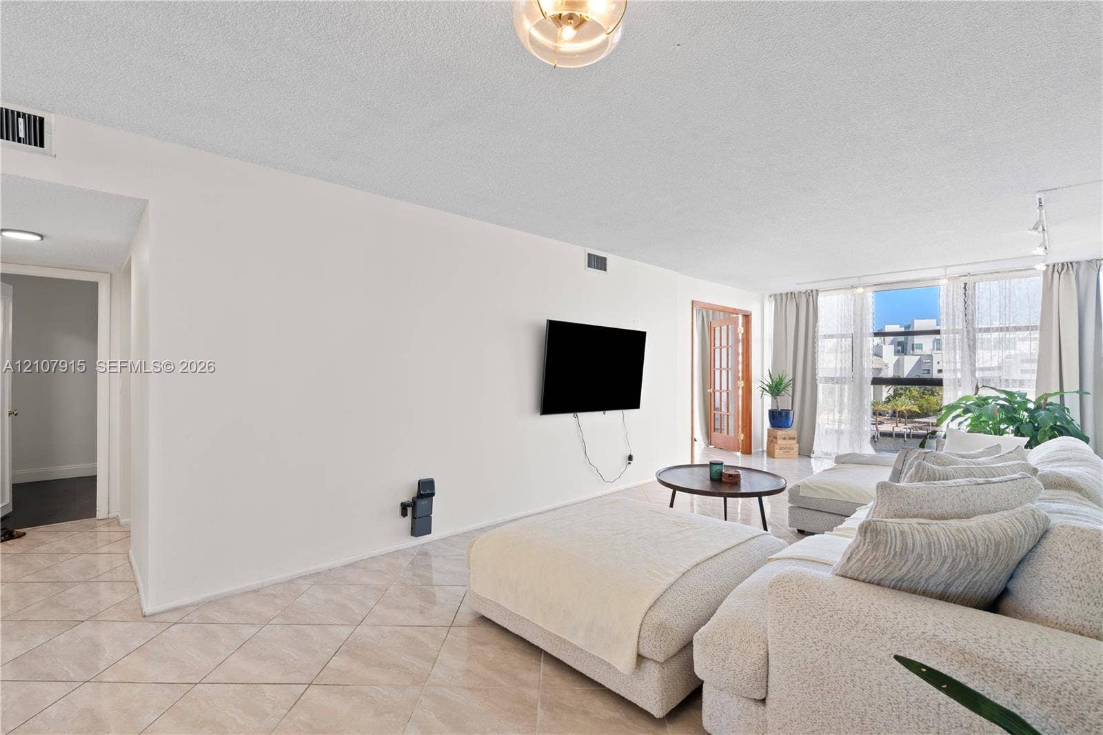 400 Leslie Drive, #622, Hallandale Beach, Hallandale Beach, FL 33009 Open-concept room featuring light-colored tile flooring set on a diagonal, floor-to-ceiling windows, and wood-framed glass pane interior doors
