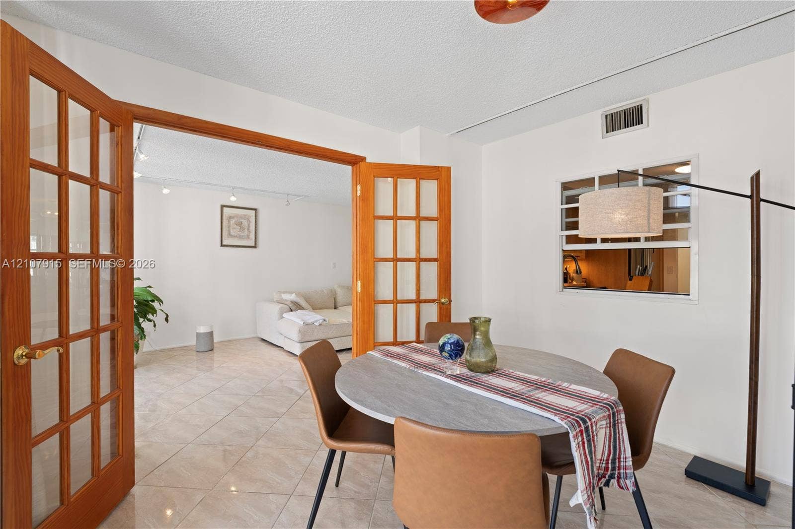400 Leslie Drive, #622, Hallandale Beach, Hallandale Beach, FL 33009 Interior space featuring wood-frame French doors, tile flooring, and a pass-through window with a fixed pane
