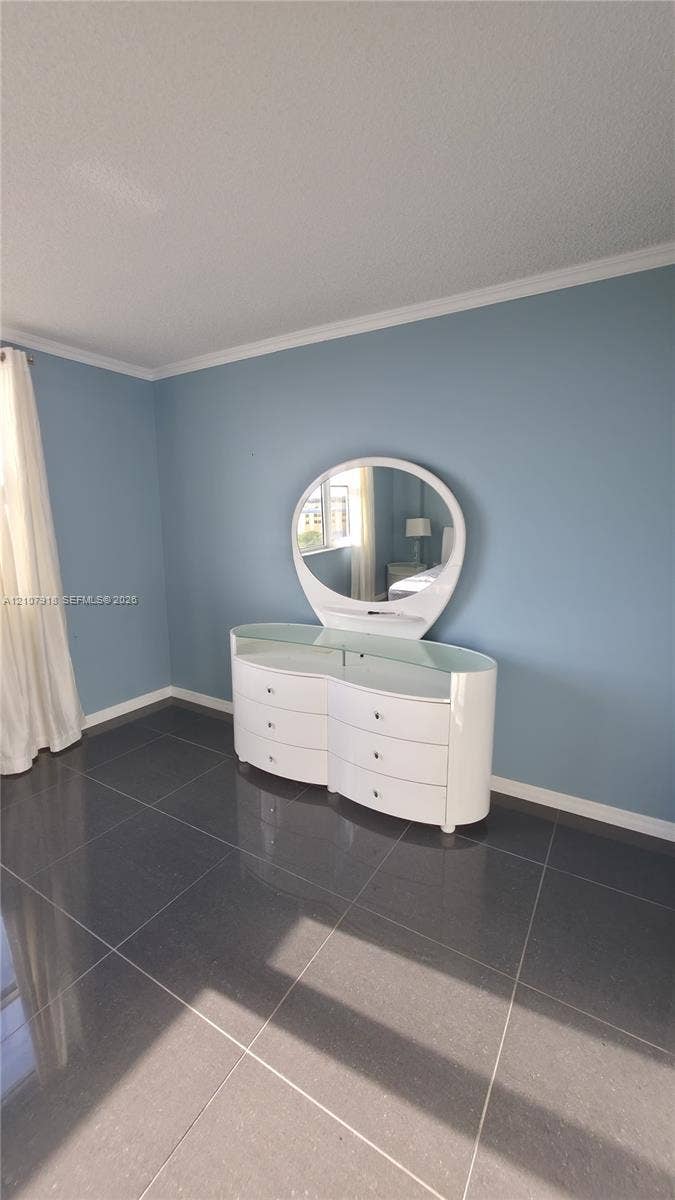 Interior space featuring dark-toned tile flooring and painted walls