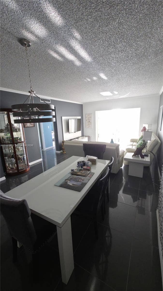 Polished tile flooring, recessed lighting, and a multi-tier metal chandelier fixture