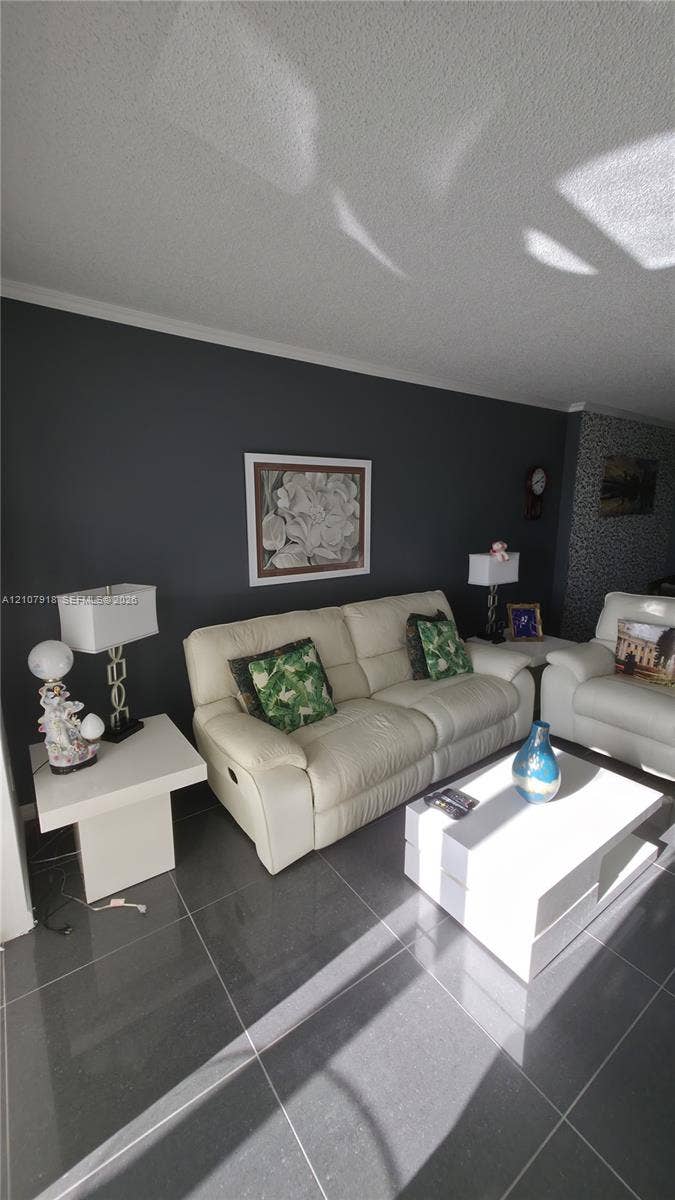 Living area featuring dark-toned stone-finish tile flooring and a charcoal accent wall