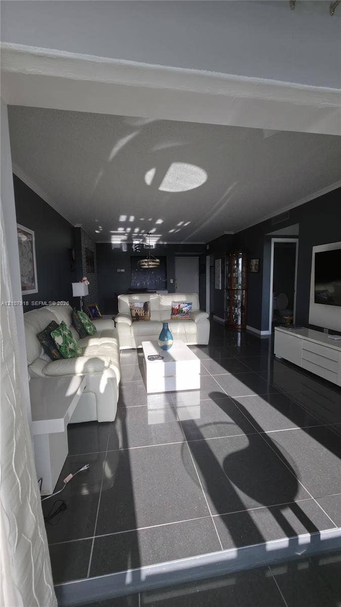 Open-concept living space featuring large-format dark floor tiles and deep-toned wall finishes