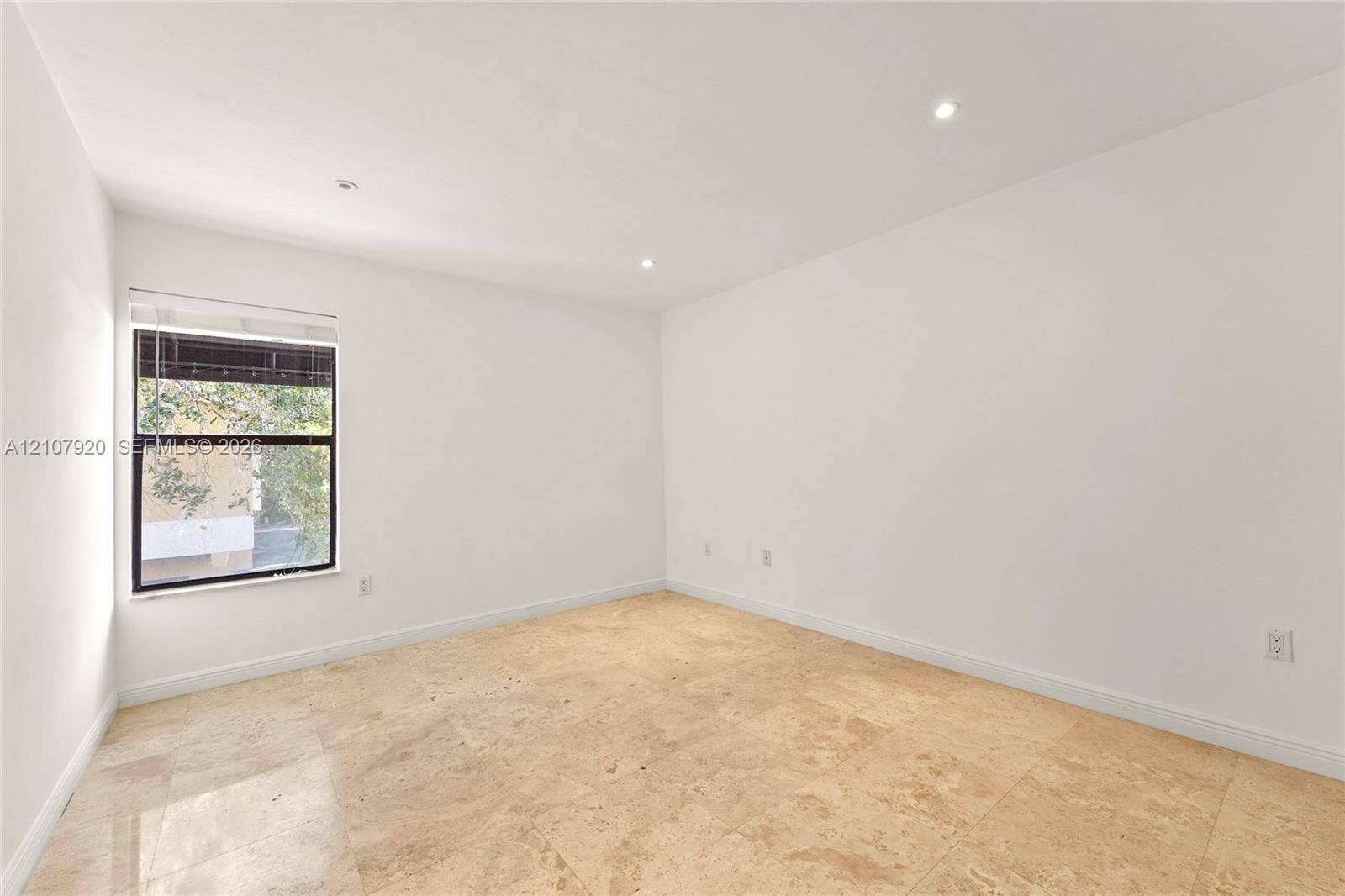 3062 Shipping Avenue, #3062, Miami, Miami, FL 33133 Bright corner room featuring abundant natural light from a large multi-pane window, recessed ceiling lighting, smooth drywall finishes, and light wood-finish flooring throughout