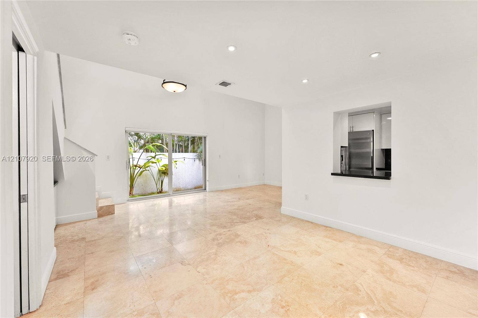 3062 Shipping Avenue, #3062, Miami, Miami, FL 33133 Open-concept living space featuring high ceilings, light-toned stone-finish flooring, recessed lighting, and large sliding glass doors