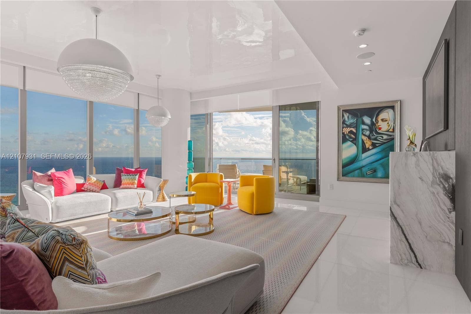 Floor-to-ceiling windows, polished stone flooring, custom stone-clad fireplace surround, recessed ceiling lighting, and pendant globe fixtures