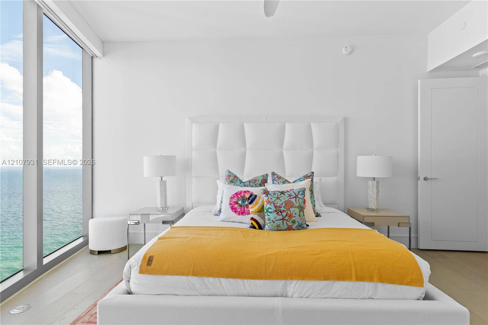 Floor-to-ceiling windows, wood-finish flooring, and white interior finishes