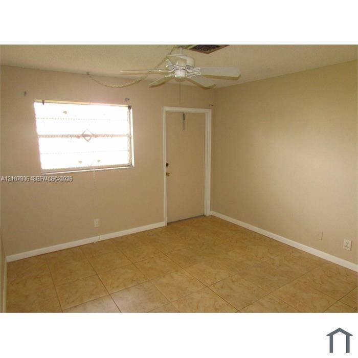 2839 Taylor Street, #3, Hollywood, Hollywood, FL 33020 Interior space featuring tile flooring, a window with security bars, and a ceiling fan with integrated lighting