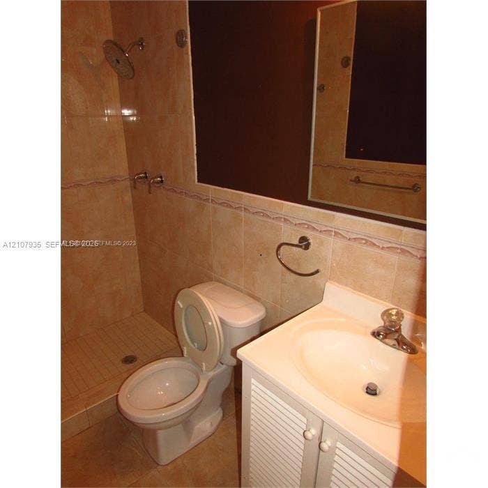 2839 Taylor Street, #3, Hollywood, Hollywood, FL 33020 Full-height tiled walk-in shower with integrated wall-mounted showerhead, vanity with integrated basin and polished metal faucet, and large rectangular wall-mounted mirror