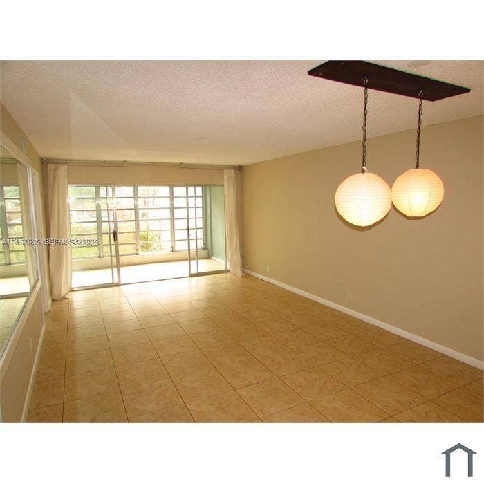 2839 Taylor Street, #3, Hollywood, Hollywood, FL 33020 Ceramic tile flooring, sliding glass patio doors, wall-mounted mirror, and dual spherical globe pendant lighting