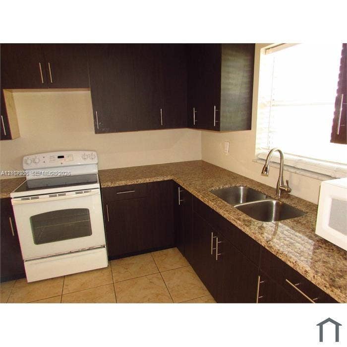 2839 Taylor Street, #3, Hollywood, Hollywood, FL 33020 Kitchen featuring dark-toned cabinetry, stone-finish countertops, stainless steel dual-basin undermount sink with a gooseneck faucet, white electric range, and tile flooring