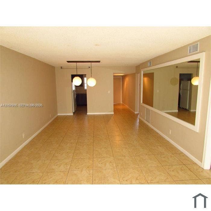 2839 Taylor Street, #3, Hollywood, Hollywood, FL 33020 Interior space featuring tile flooring, a large wall-mounted mirror, and dual spherical pendant lighting