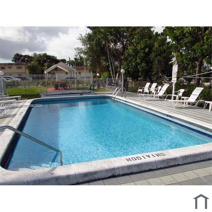 2839 Taylor Street, #3, Hollywood, Hollywood, FL 33020 Rectangular in-ground swimming pool featuring a concrete coping surround, metal pool ladder, and expansive light-toned paver deck