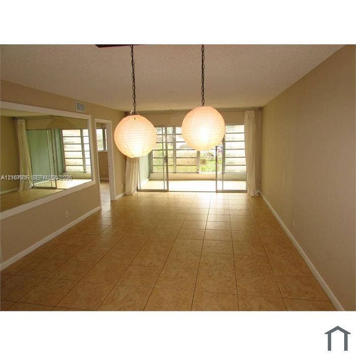 2839 Taylor Street, #3, Hollywood, Hollywood, FL 33020 Ceramic tile flooring, dual globe pendant lighting, wall-mounted mirror, and floor-to-ceiling sliding glass doors