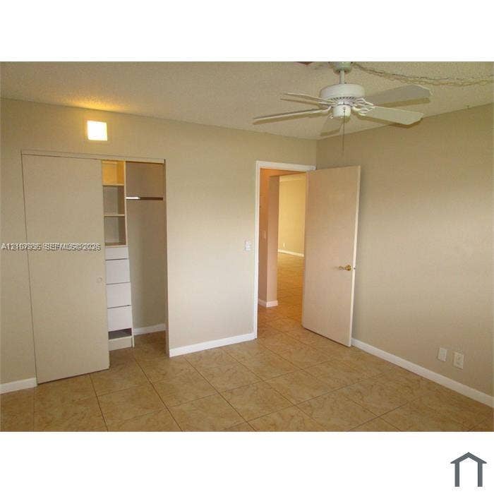2839 Taylor Street, #3, Hollywood, Hollywood, FL 33020 Ceramic tile flooring, white ceiling fan with integrated lighting, and built-in closet cabinetry with shelving and drawers
