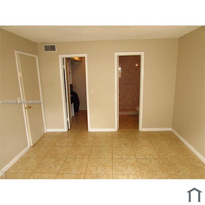 2839 Taylor Street, #3, Hollywood, Hollywood, FL 33020 Neutral-toned room featuring large-format ceramic tile flooring, two solid-core interior doors, and built-in closet shelving