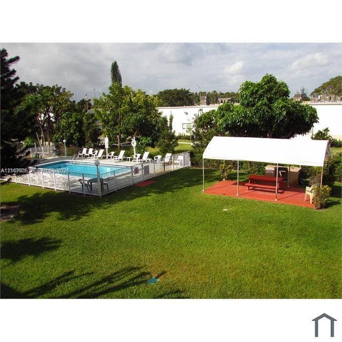 2839 Taylor Street, #3, Hollywood, Hollywood, FL 33020 Outdoor area featuring an in-ground swimming pool with perimeter fencing, a covered patio structure, and a lawn