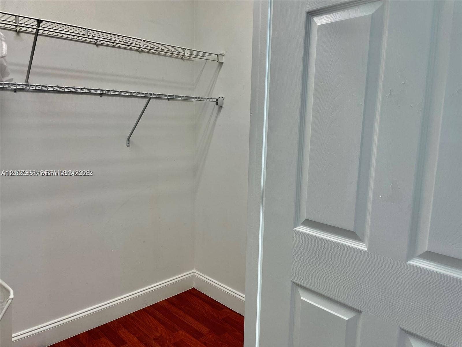 3370 Hidden Bay Drive, #510, Aventura, FL 33180 Storage area featuring white paneled door, wood-finish flooring, and tiered wire shelving
