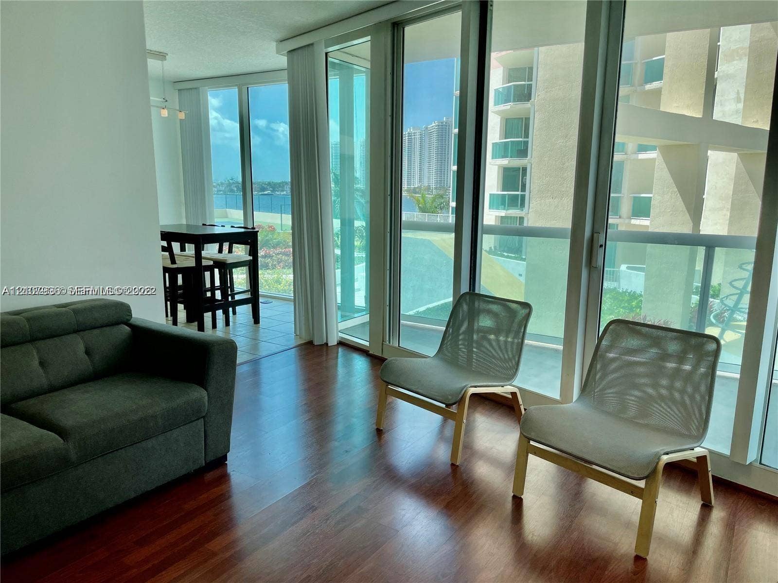 3370 Hidden Bay Drive, #510, Aventura, FL 33180 Floor-to-ceiling glass panel windows, wood-finish flooring, and access to a balcony with glass railings