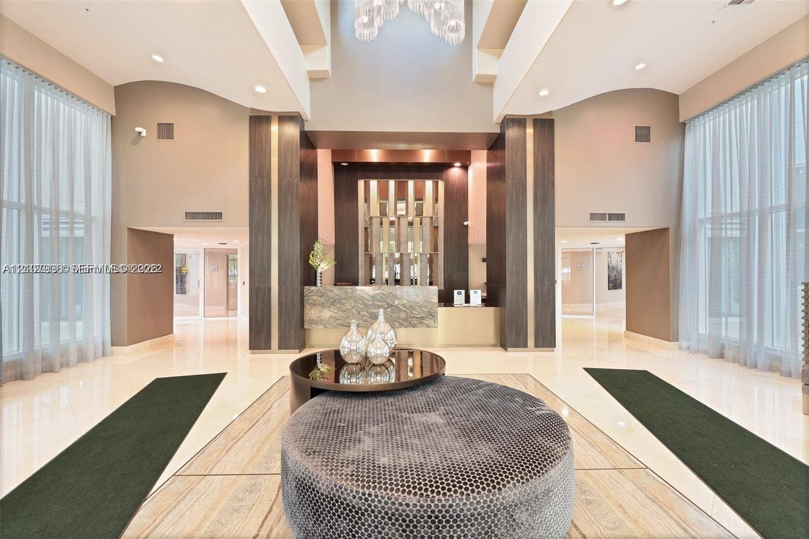 3370 Hidden Bay Drive, #510, Aventura, FL 33180 Double-height ceiling, floor-to-ceiling windows, polished stone flooring, custom architectural columns, and a stone-clad reception desk