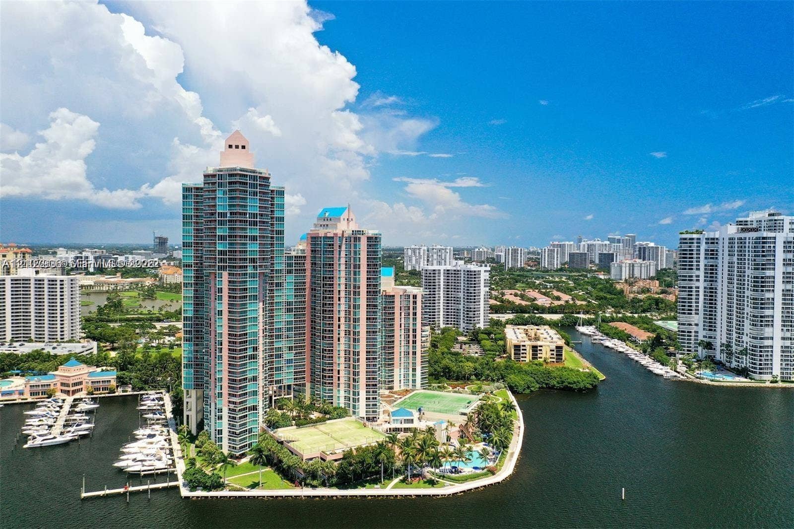 3370 Hidden Bay Drive, #510, Aventura, FL 33180 High-rise residential towers featuring private marina slips, tennis courts, and landscaped grounds situated on a waterfront peninsula