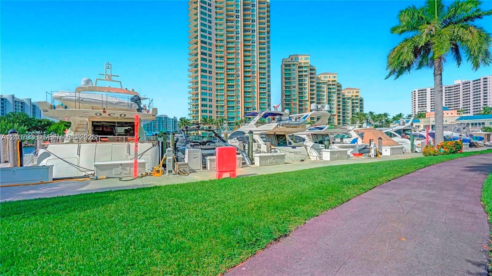 3370 Hidden Bay Drive, #510, Aventura, FL 33180 Waterfront promenade featuring a paved walkway, manicured lawn, and deep-water marina access