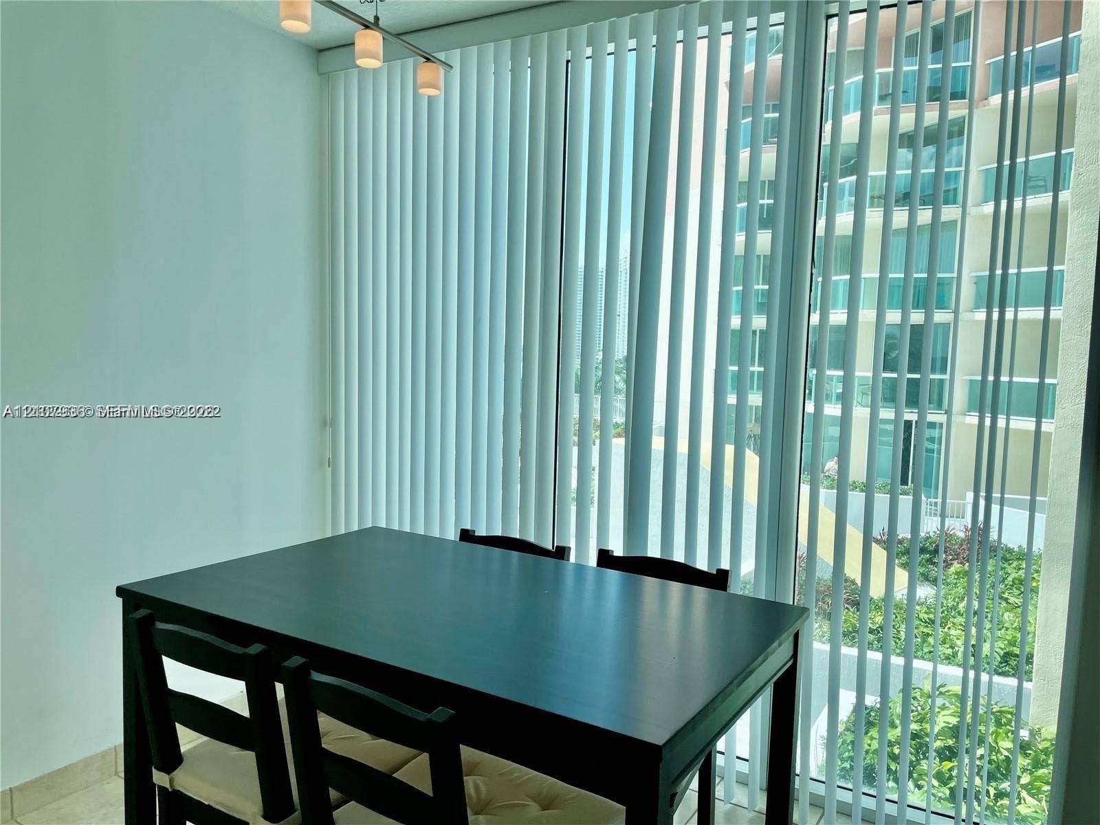 3370 Hidden Bay Drive, #510, Aventura, FL 33180 Floor-to-ceiling windows featuring vertical blinds, neutral tile flooring, and a three-light bar pendant fixture
