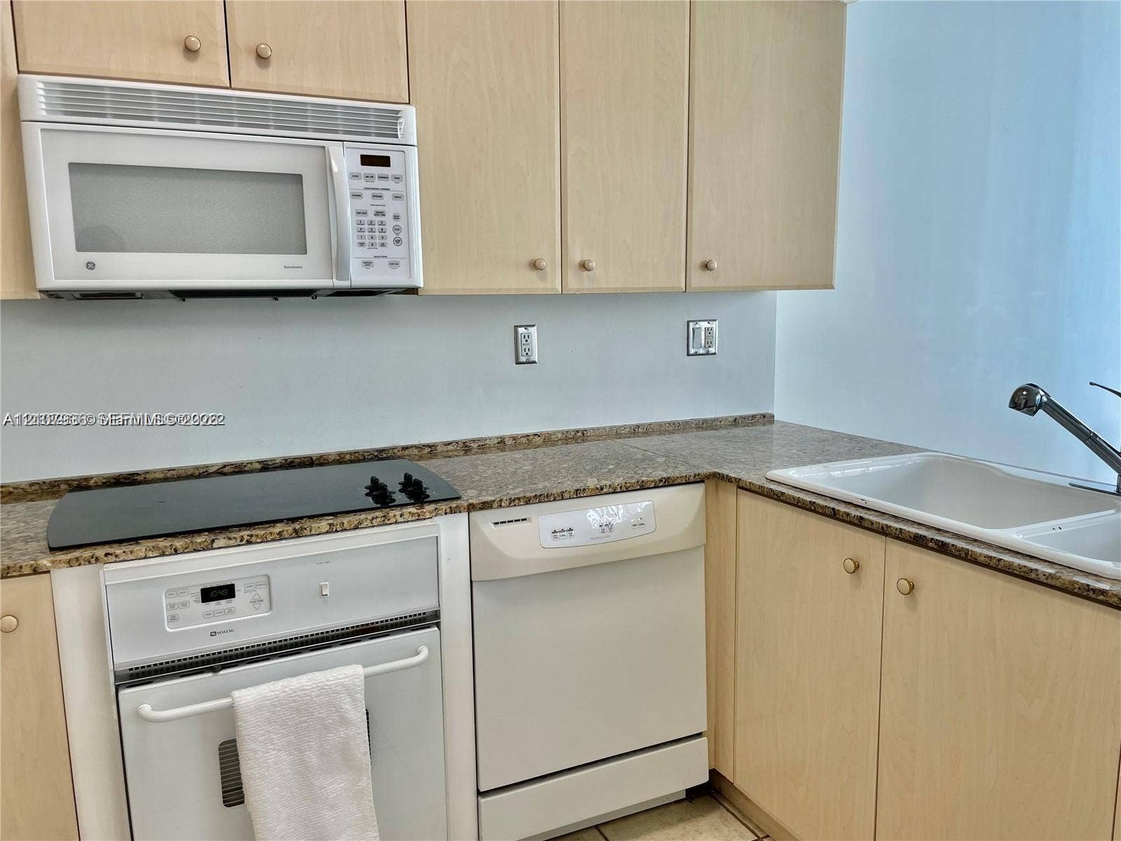 3370 Hidden Bay Drive, #510, Aventura, FL 33180 Kitchen featuring light wood-finish cabinetry, stone-surface countertops, built-in microwave, electric cooktop, and an integrated dishwasher