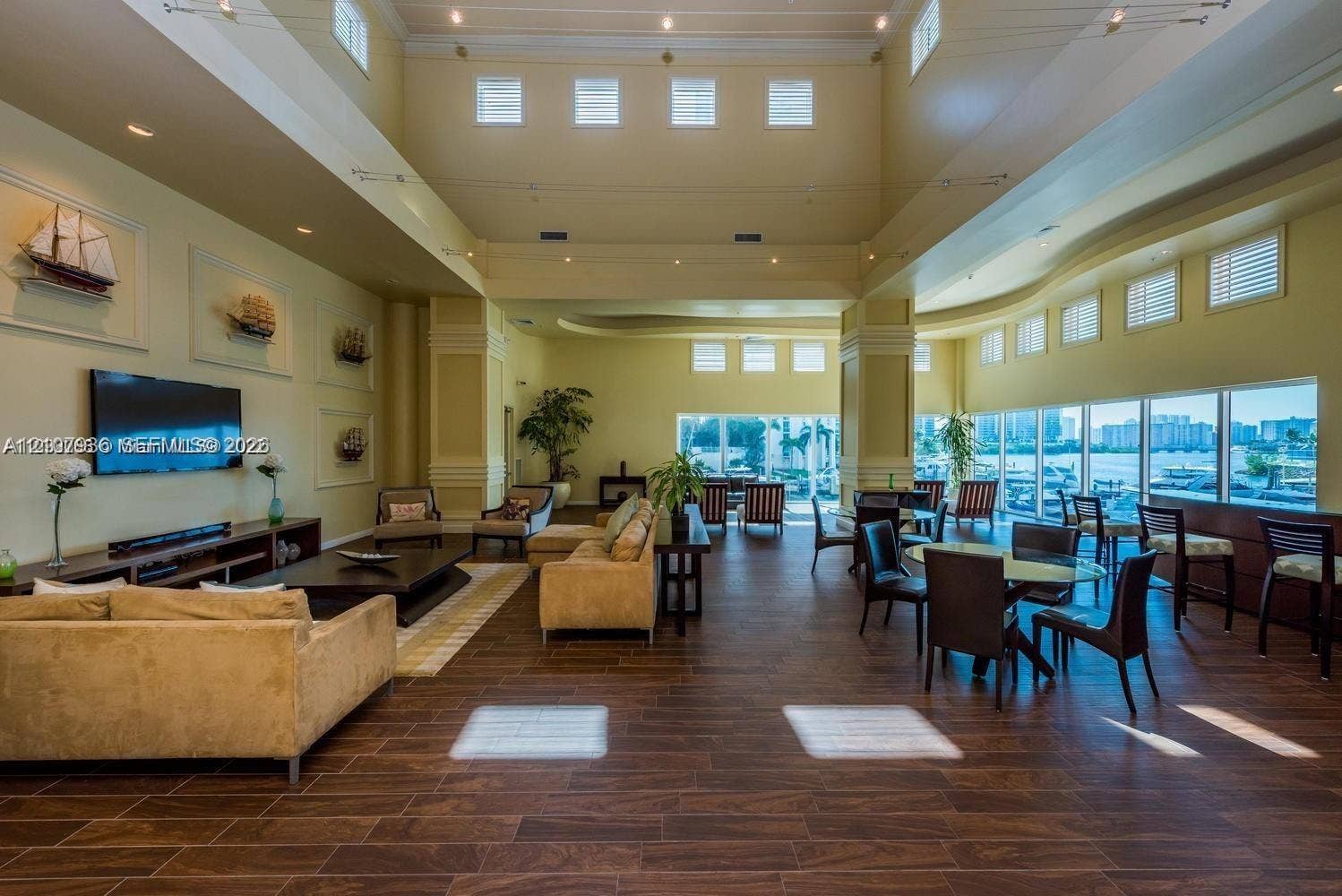 3370 Hidden Bay Drive, #510, Aventura, FL 33180 Expansive common area featuring soaring ceilings, wood-finish flooring, numerous clerestory windows, and floor-to-ceiling glass paneling