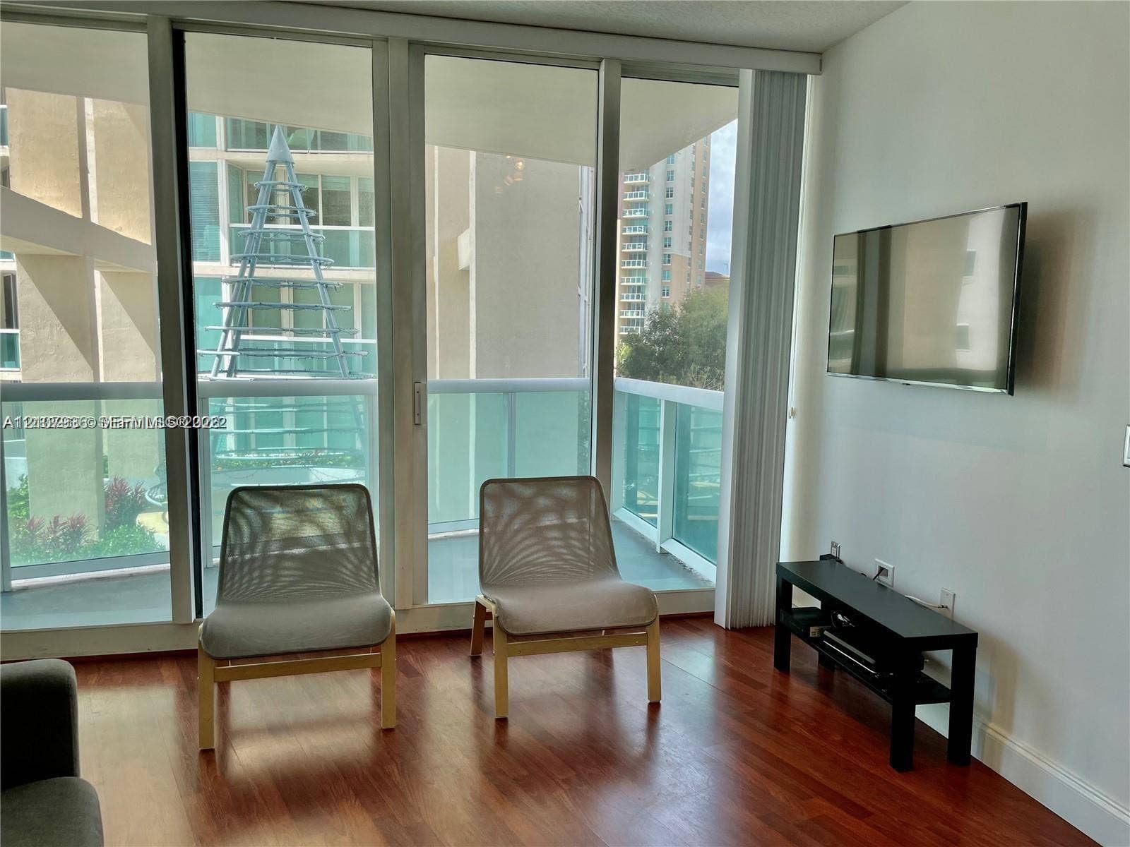 3370 Hidden Bay Drive, #510, Aventura, FL 33180 Floor-to-ceiling windows, wood-finish flooring, and access to a balcony with glass railings