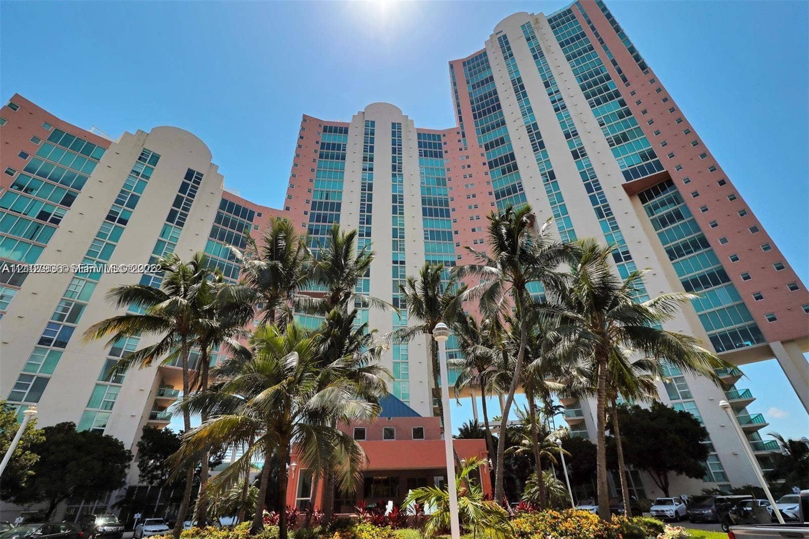 3370 Hidden Bay Drive, #510, Aventura, FL 33180 High-rise architectural exterior featuring multi-story glass facade, tiered building design, and expansive glass window installations complemented by manicured palm landscaping