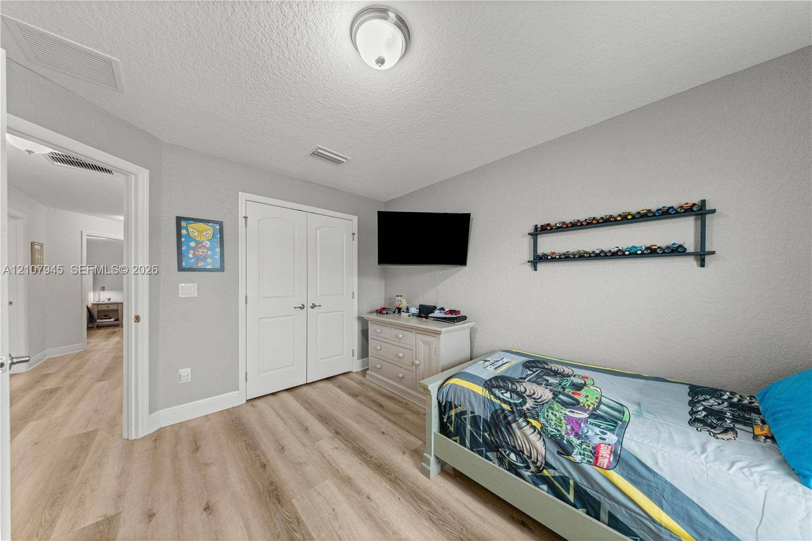 Wood-finish flooring, double-panel interior closet doors, and flush-mount ceiling lighting