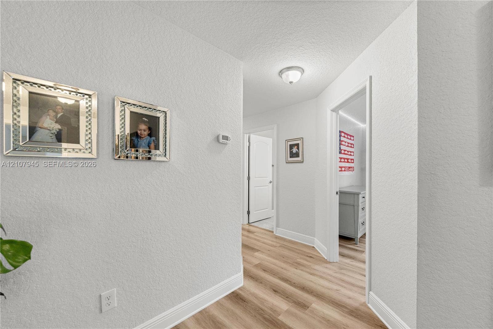 Neutral-toned interior featuring wood-finish flooring, textured wall surfaces, and crisp white trim