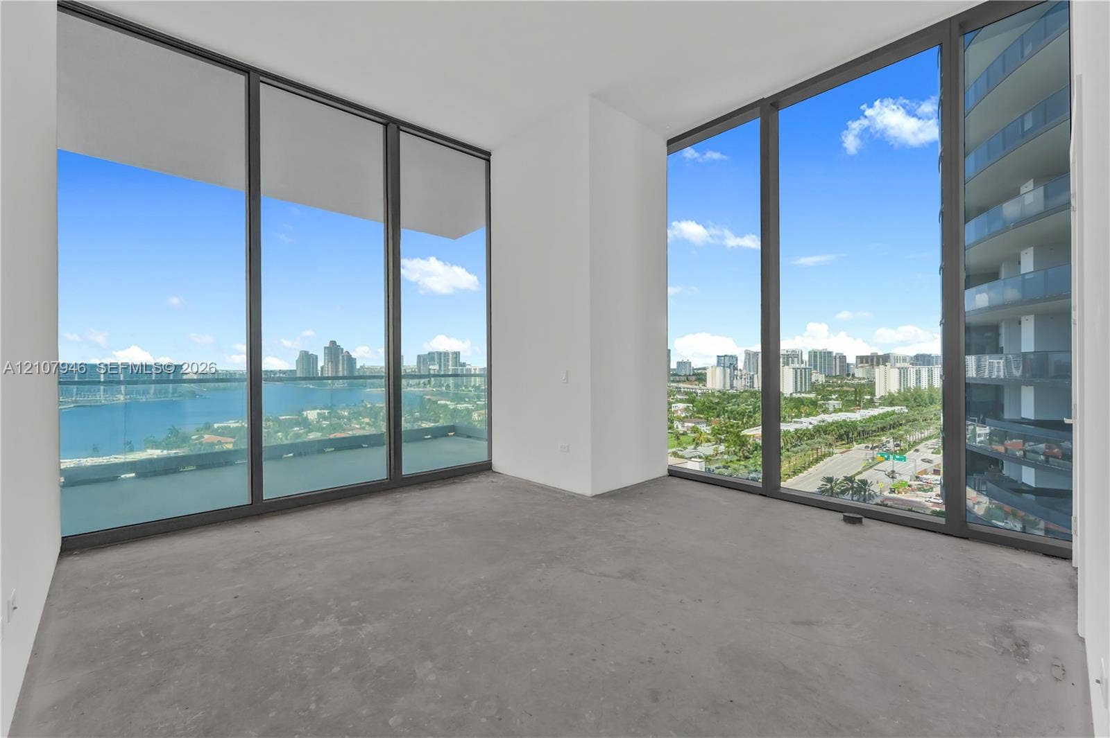 Floor-to-ceiling windows with dark-finish frames, panoramic exterior scenery, and smooth concrete flooring