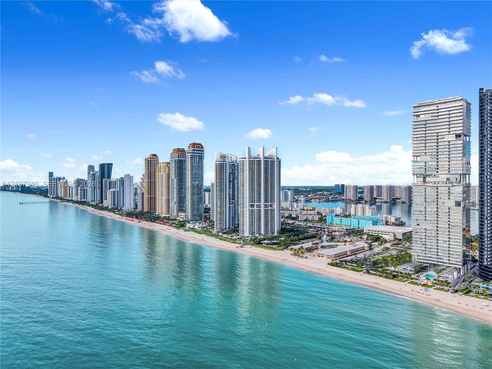 Aerial perspective featuring an extensive shoreline, coastal waters, and high-rise structures