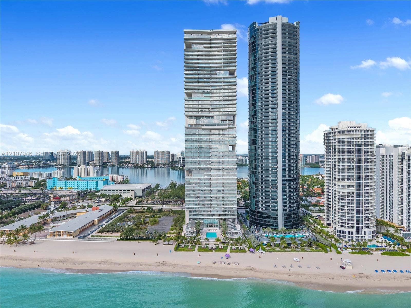 High-rise residential towers featuring floor-to-ceiling glass facades, direct beach access, and ground-level outdoor swimming pools